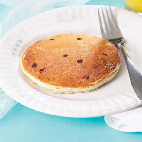 Delicious protein pancakes on a white plate, featuring chocolate chips, ready to be enjoyed for a healthy breakfast.